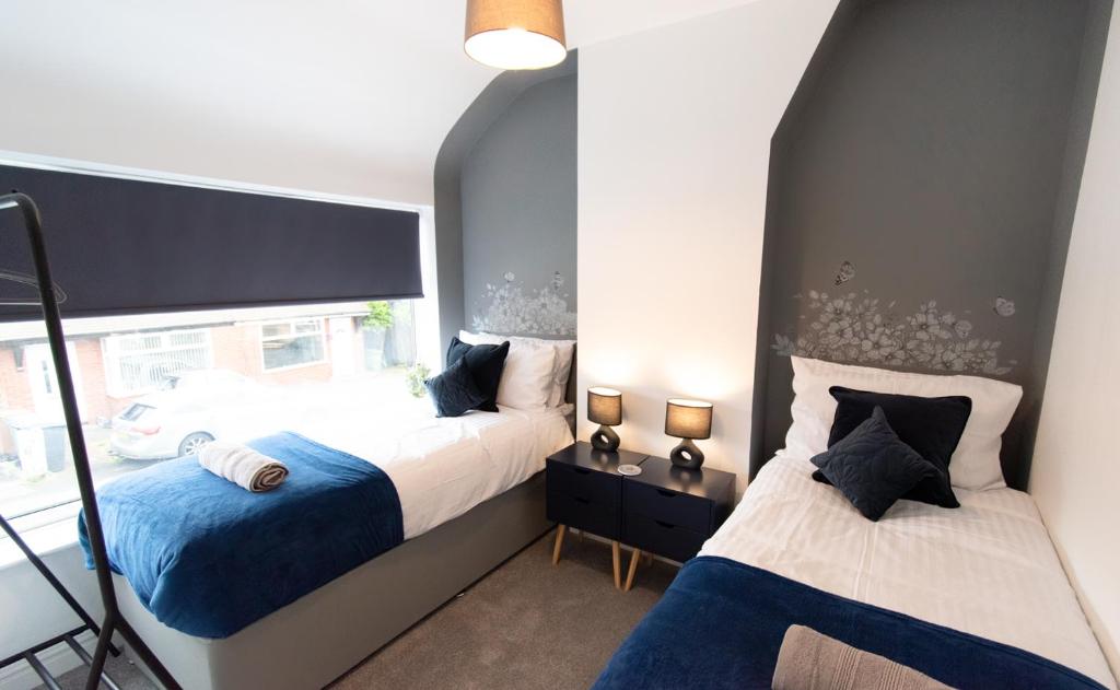 um quarto com 2 camas e uma janela em Ideal Lodgings In Audenshaw em Manchester