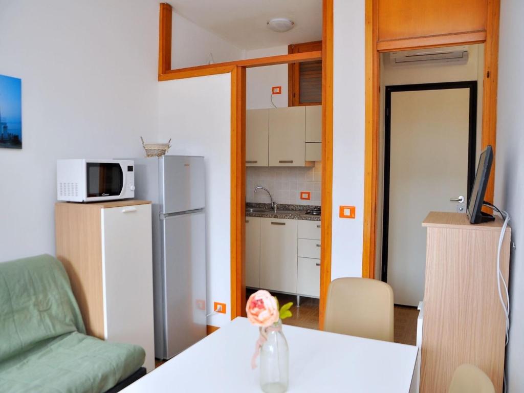 ein Wohnzimmer mit einem Tisch und einer Küche in der Unterkunft Seaside bright flat with terrace - Beahost in Bibione