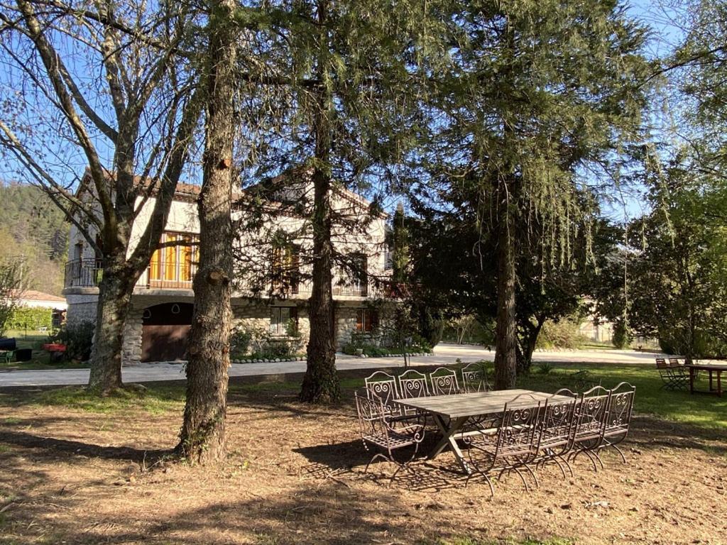 einen Picknicktisch und Stühle in einem Park mit Bäumen in der Unterkunft NOUVEAU Villa Olga in Jaujac