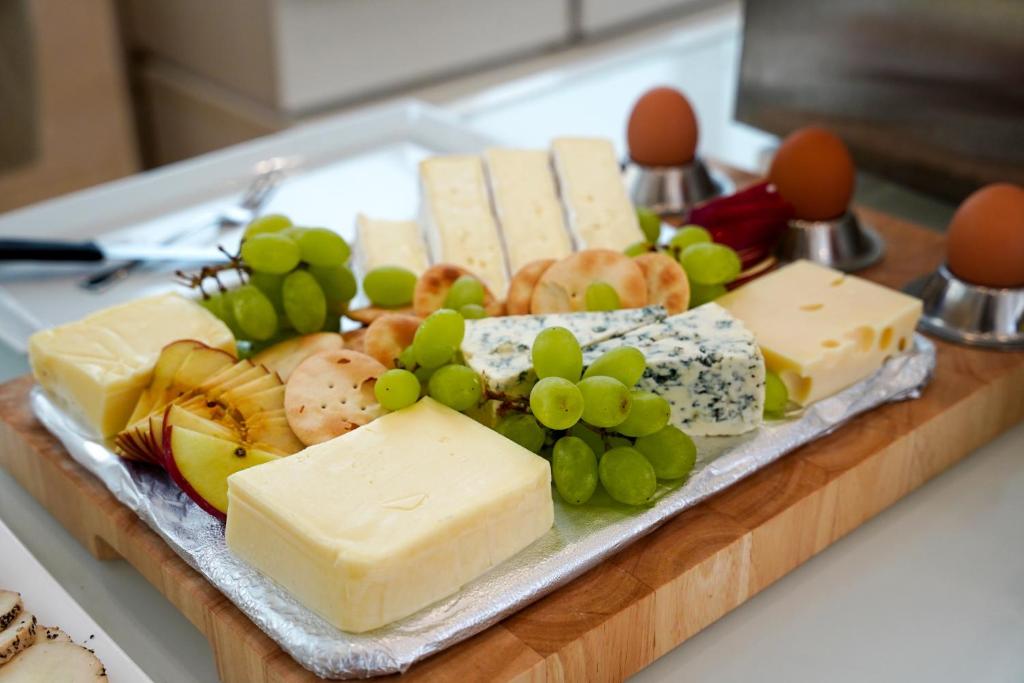 a tray of cheeses and grapes on a table at The Maltese Sun in Sliema