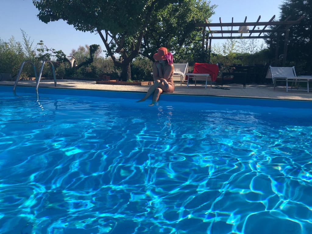 a woman in a bathing suit jumping into a swimming pool at Etna Petit Relais in Nicolosi
