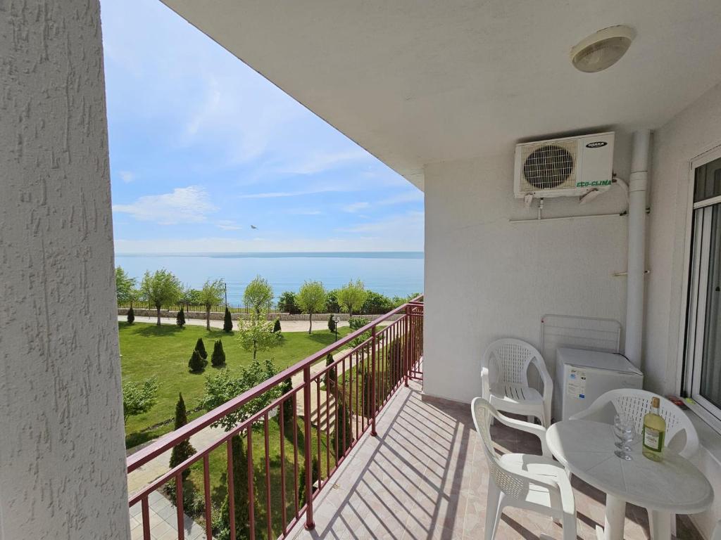 a balcony with a table and chairs and a view of the ocean at Apartment Fort Noks in Sveti Vlas