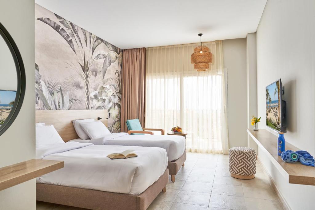 una camera d'albergo con due letti e un divano di Three Corners Sunny Beach Resort a Hurghada