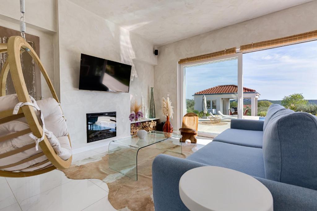 salon z niebieską kanapą i kominkiem w obiekcie Villa Nebesi ZadarVillas w mieście Pristeg
