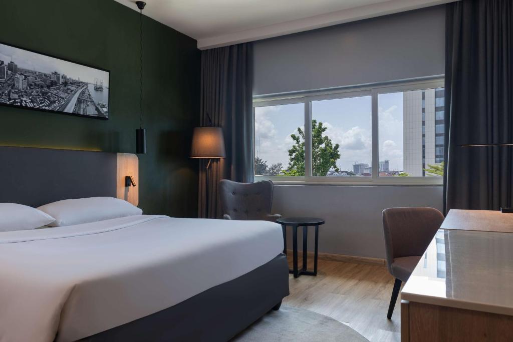 a hotel room with a bed and a window at Park Inn by Radisson, Lagos Victoria Island in Lagos
