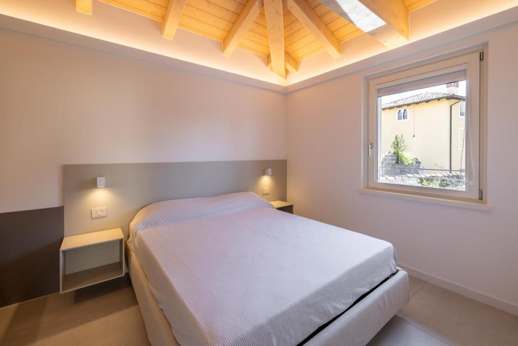ein Schlafzimmer mit einem weißen Bett und einem Fenster in der Unterkunft Il Giardino Segreto in Cividale del Friuli