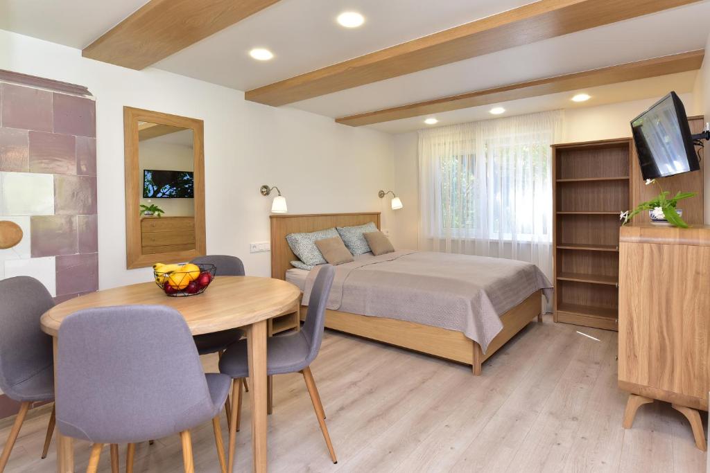 een slaapkamer met een bed en een tafel en stoelen bij SMILTIS in Palanga