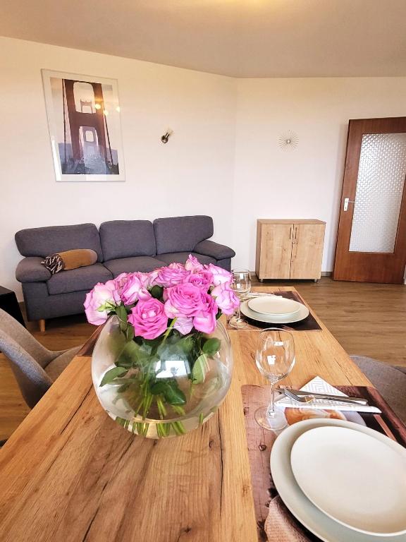 une table avec un vase de roses roses sur elle dans l'établissement Winterberg Appartement 21123, à Winterberg