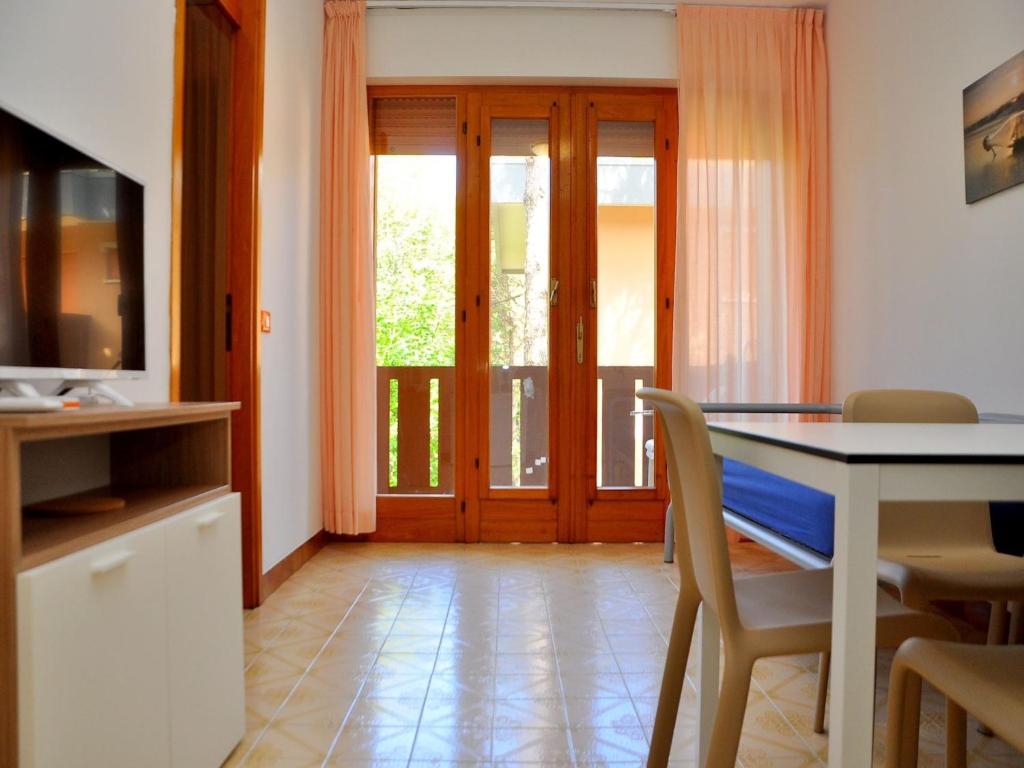 eine Küche und ein Esszimmer mit einem Tisch und einem TV in der Unterkunft Spacious and bright flat near the beach - Beahost in Bibione