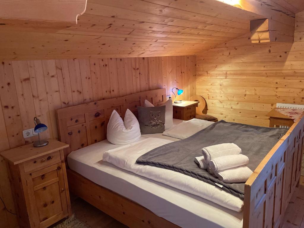 1 dormitorio con 1 cama en una cabaña de madera en Au Alm en Söll