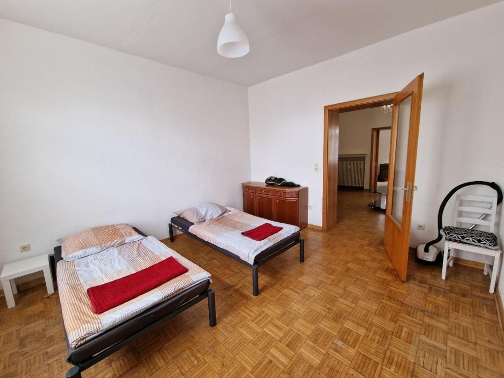 a room with two beds and a chair in it at K&K Unterkunft GbR, Wohunung 3 in Duisburg