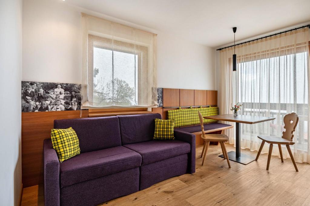ein Wohnzimmer mit einem lila Sofa und einem Tisch in der Unterkunft Haus Tirol Apt Lausgitsch in Lajen