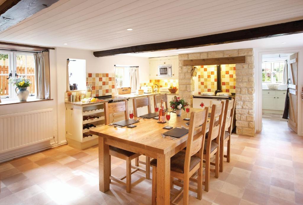 a kitchen with a wooden table and chairs at Rose Cottage Dorset in Powerstock