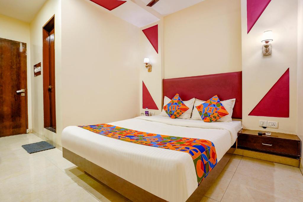 a bedroom with a large bed with colorful pillows at FabHotel D69 Residency in Mire