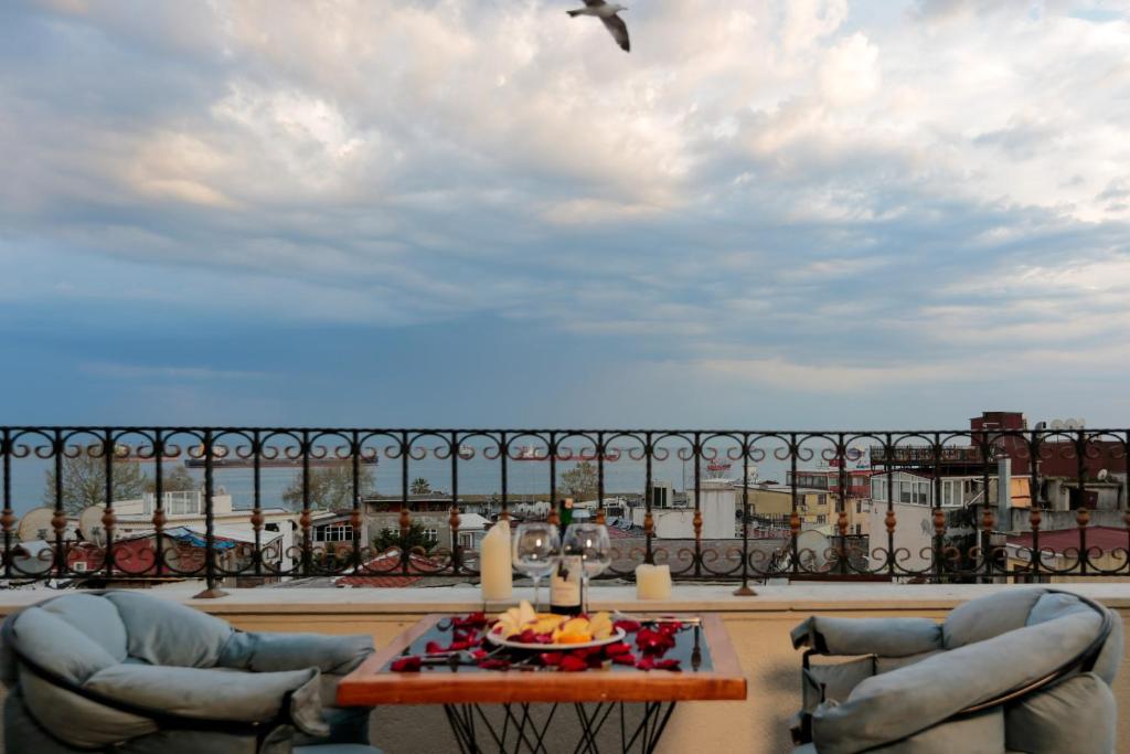 Un balcón con 2 sillas, una mesa y un pájaro en Grand Inova Hotel en Estambul