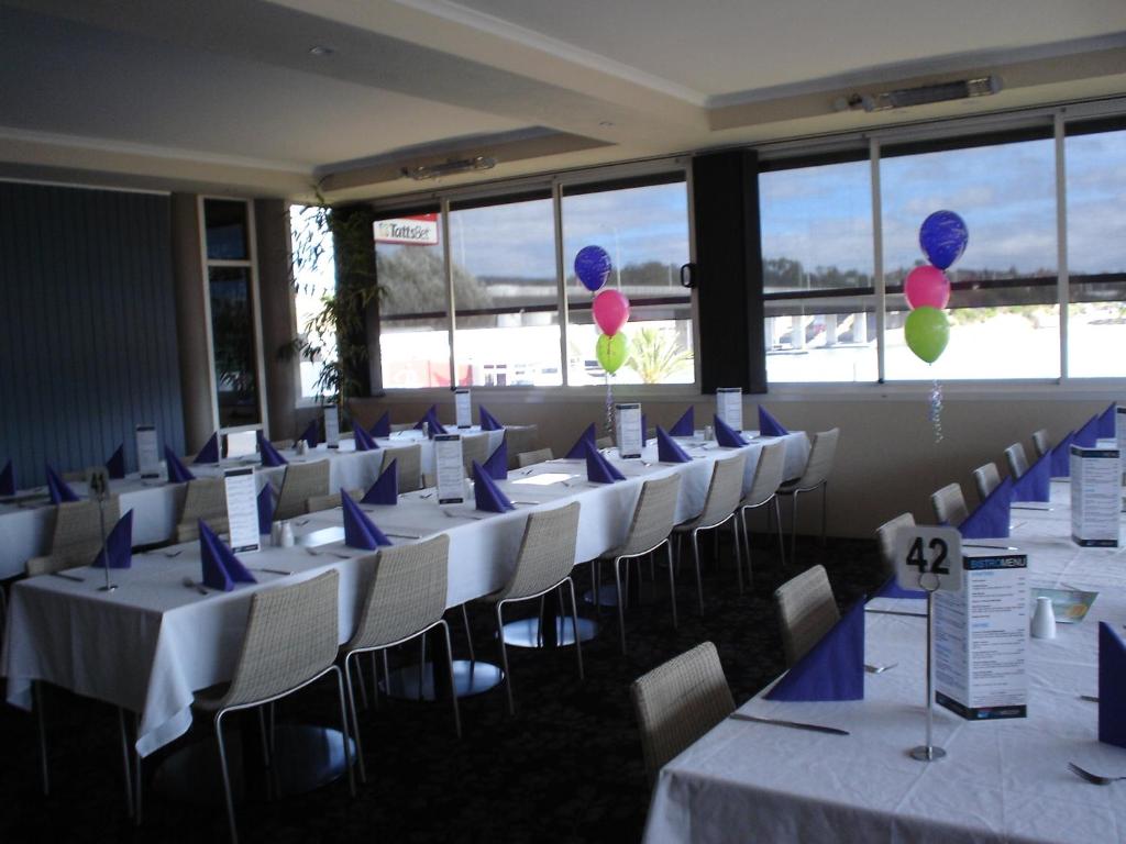 a row of tables and chairs in a room at Argosy Motor Inn in Devonport