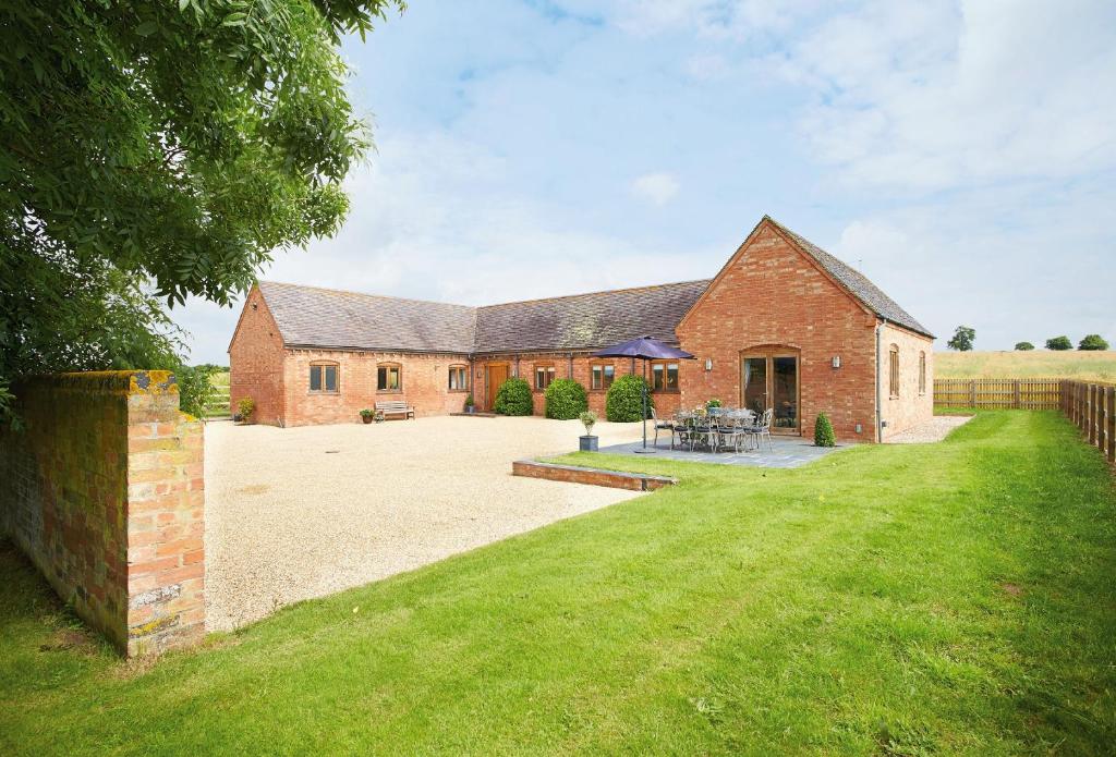 een groot bakstenen huis met een grote tuin bij Furlong Barn in Southam