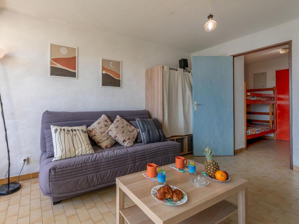 a living room with a purple couch and a table at Studio Los Amigos-6 by Interhome in Le Grau-du-Roi