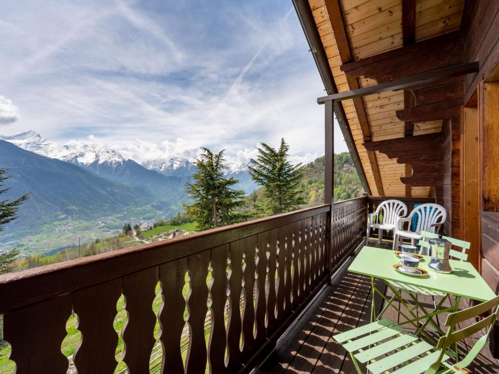 d'un balcon avec une table, des chaises et des montagnes. dans l'établissement Apartment Marmotte by Interhome, à Sarre