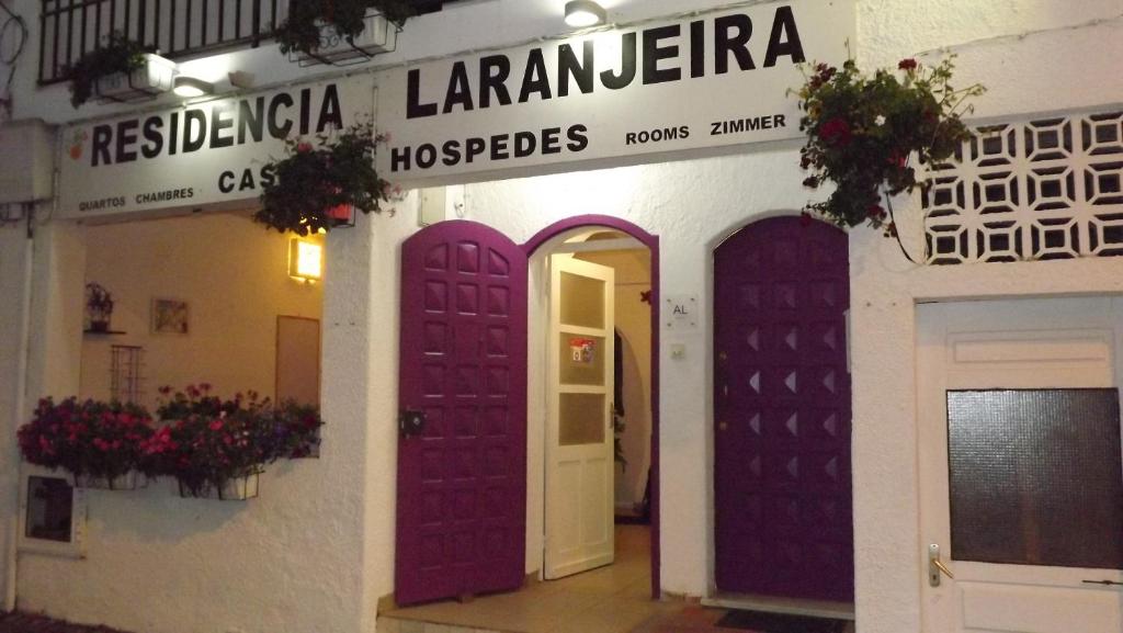 un edificio con porte viola e fiori sopra di Residencia Laranjeira a Odeceixe