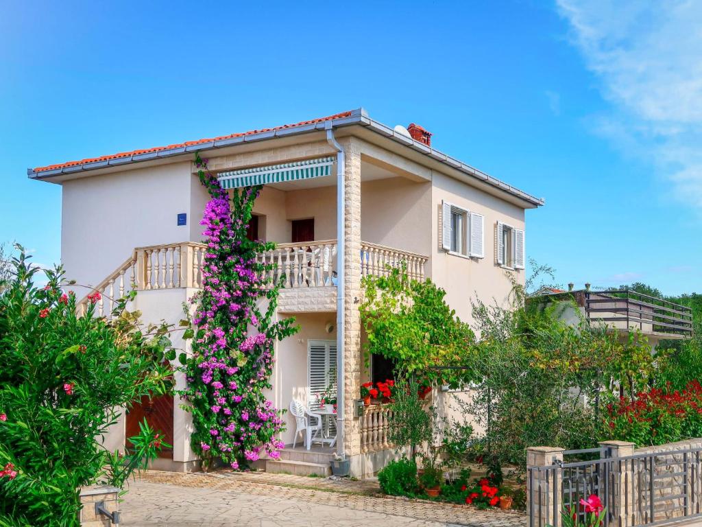 ein Haus mit Blumen davor in der Unterkunft Apartment Andjelka by Interhome in Malinska