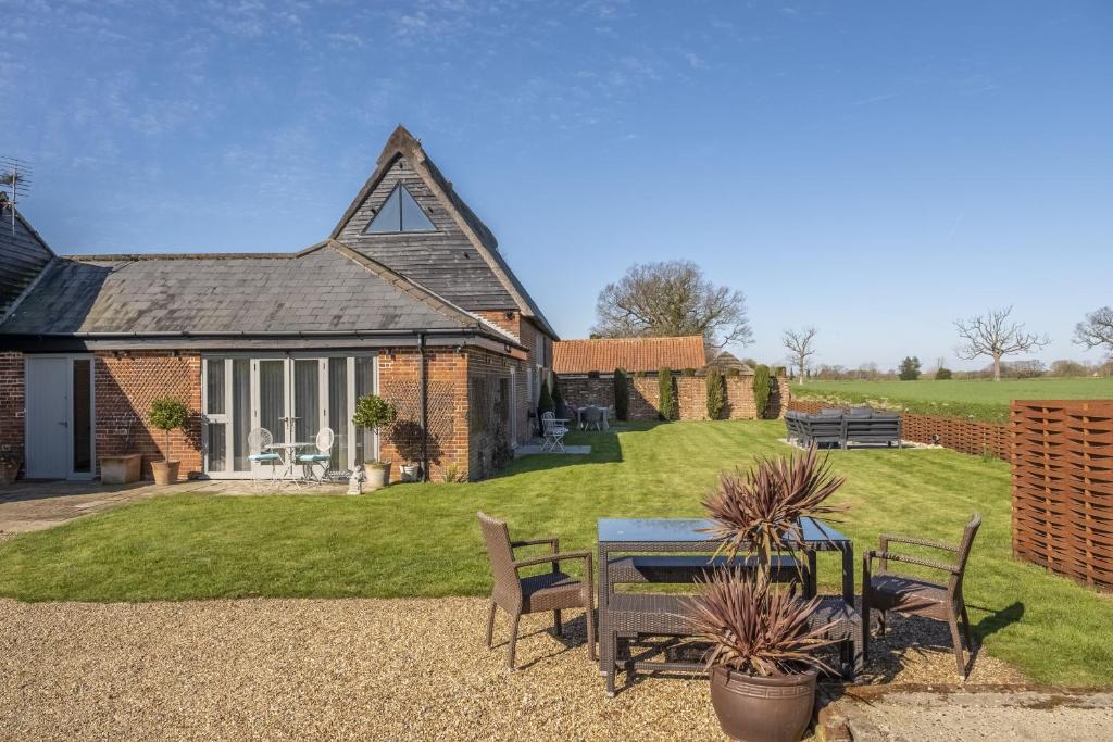 a house with a table and chairs in the yard at Thatch Barn in Lingwood