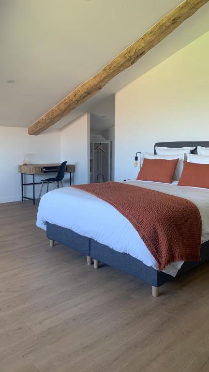 une chambre avec un grand lit et un bureau dans l'établissement Maison Divon, à Montagne