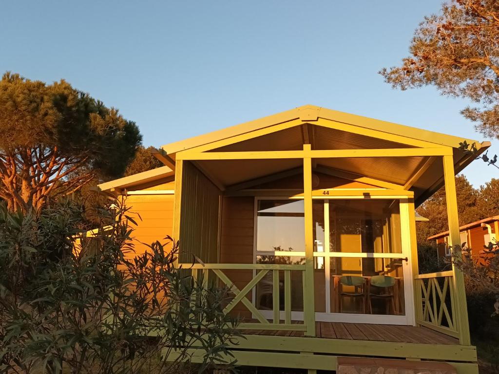 Montrás的住宿－Camping Relax Ge，一座小房子,甲板上设有大玻璃门