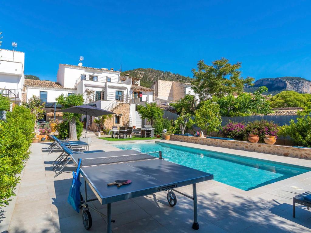 a pool with tables and chairs next to a building at Holiday Home Can Rochet by Interhome in Alaró