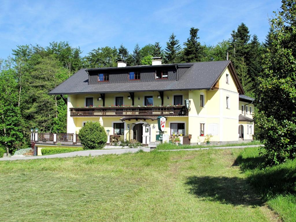 een groot geel huis met een zwart dak bij Apartment Waldfrieden by Interhome in Oberwang