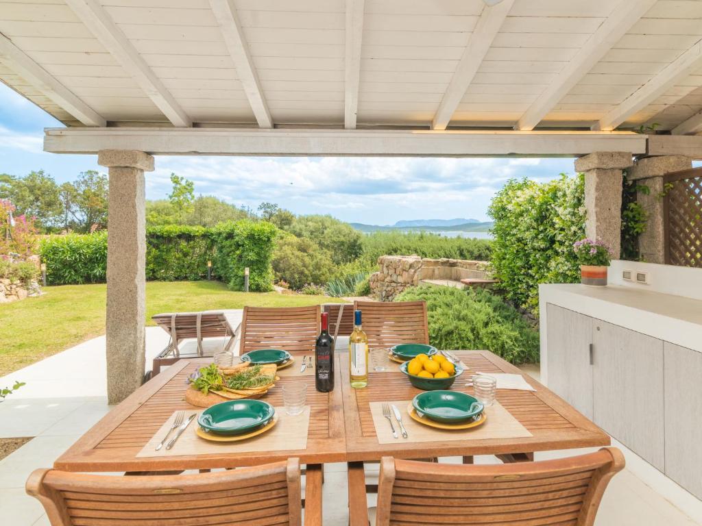 a wooden table and chairs on a patio at Apartment La Nina by Interhome in Porto Rotondo