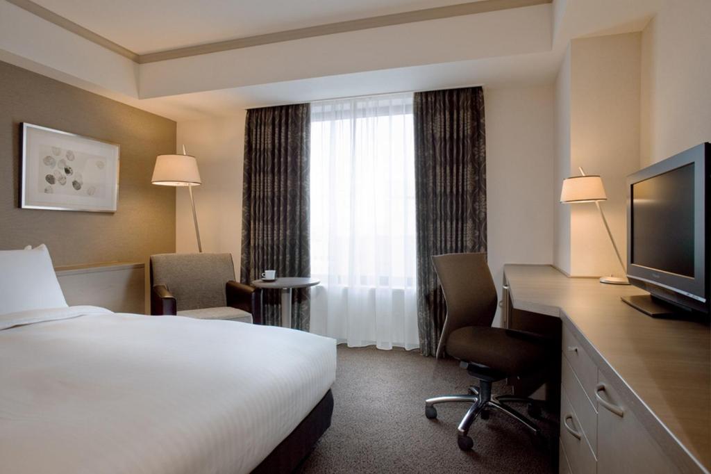a hotel room with a bed and a television at Hotel Nikko Fukuoka in Fukuoka