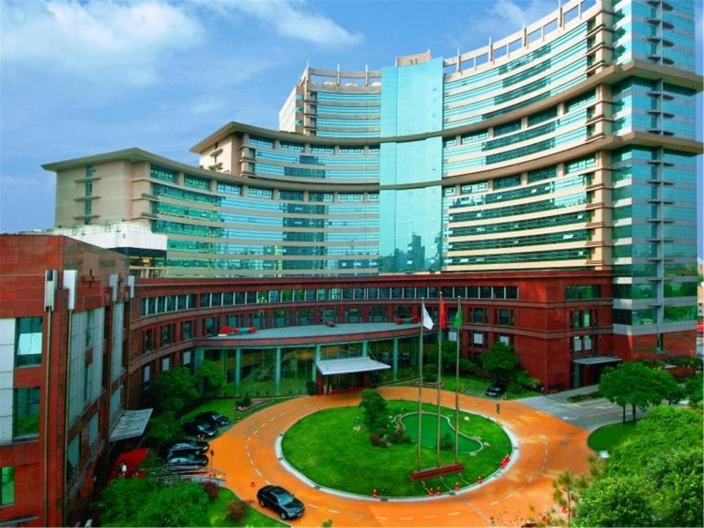 un gran edificio con una entrada circular delante de él en Jin Jiang Pine City Hotel en Shanghái