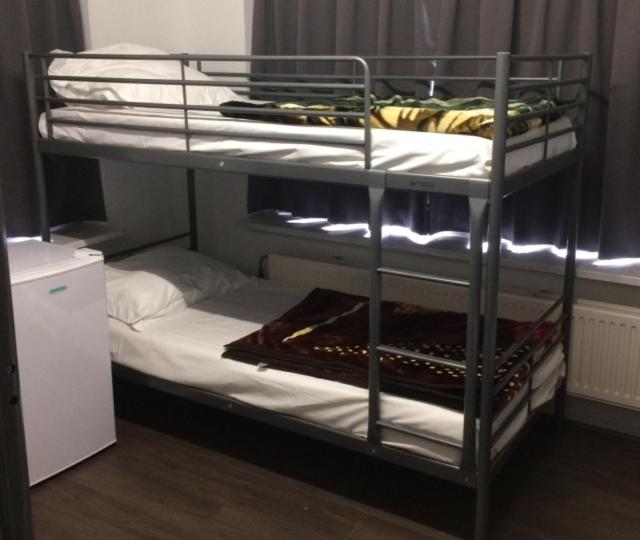 a bunk bed with white sheets and a white mattress at Guest House Amsterdam in Amsterdam