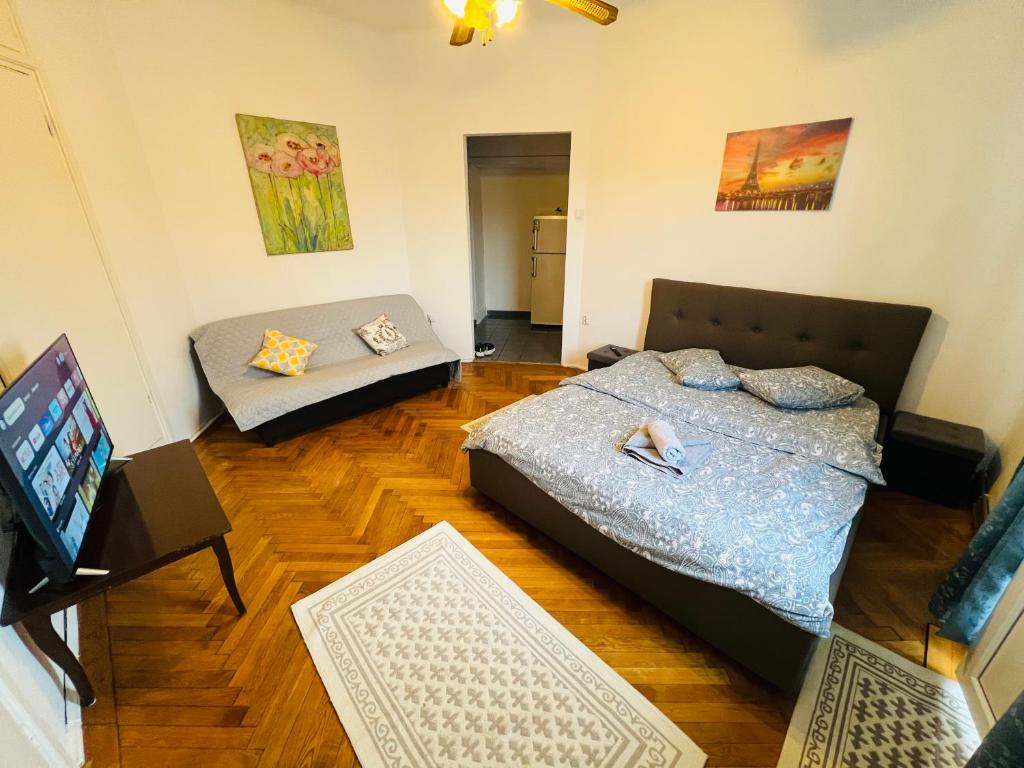sala de estar con 2 camas y sofá en Unirii Downtown Apartment, en Bucarest
