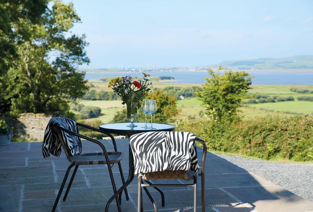 a table and two chairs with a wine glass on it at High Bridge Haven in Soutergate