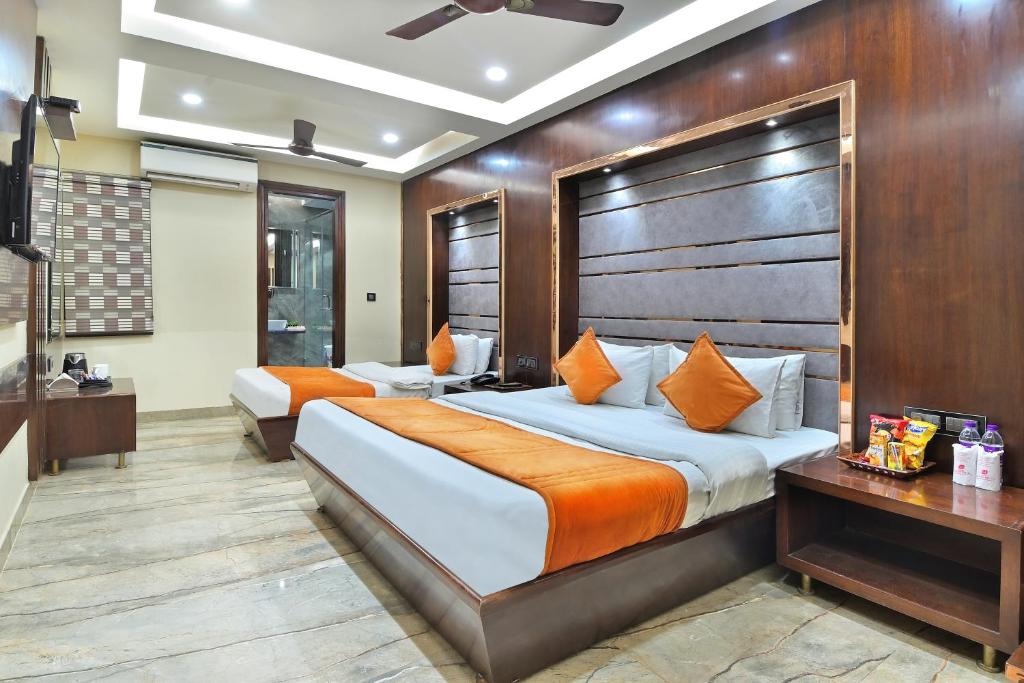 a hotel room with two beds and a desk at Hotel Vanson Delite - New Delhi Railway Station in New Delhi