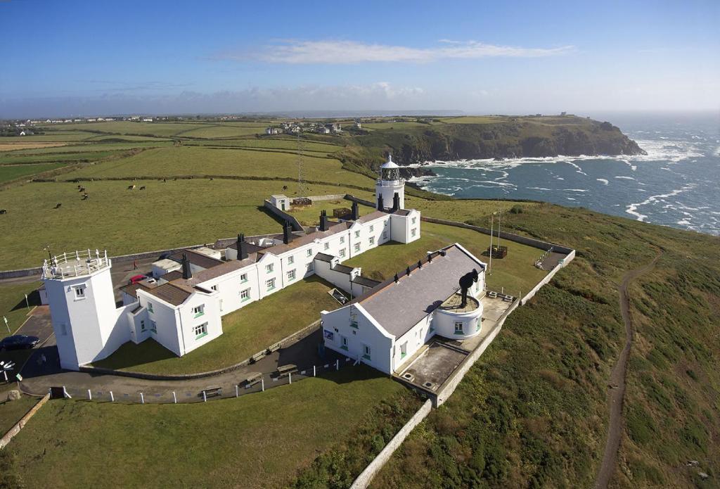 an aerial view of a white building with a lighthouse at Bishop Rock in Landewednack