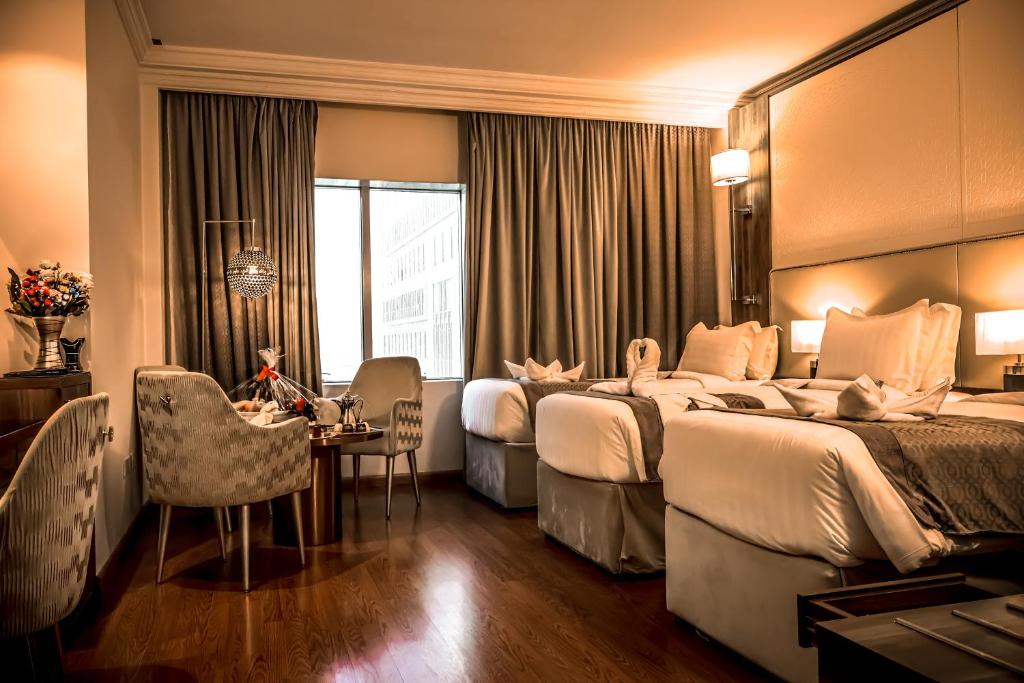 um quarto de hotel com duas camas e uma mesa em Al Ritz Al Madinah em Medina