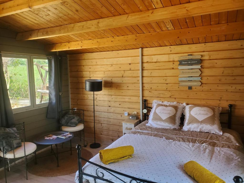 a bedroom with a bed and a wooden wall at Escale Détente en amoureux Spa en option in Allan