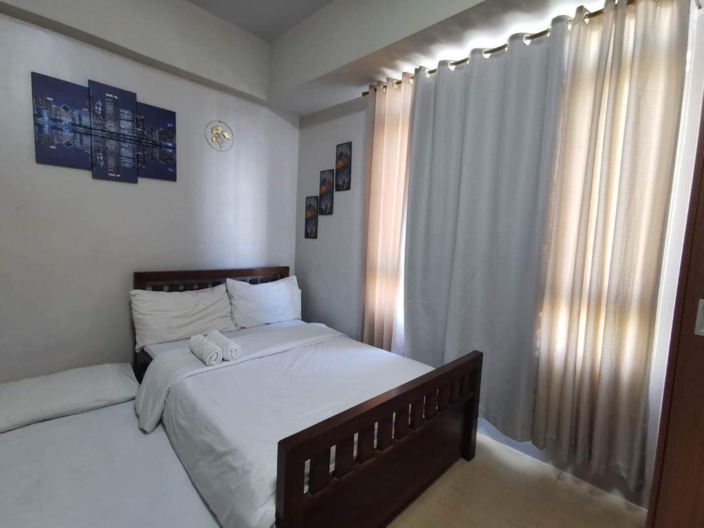 a bedroom with a large bed and a window at Entire Home @150NB pasay city in Manila