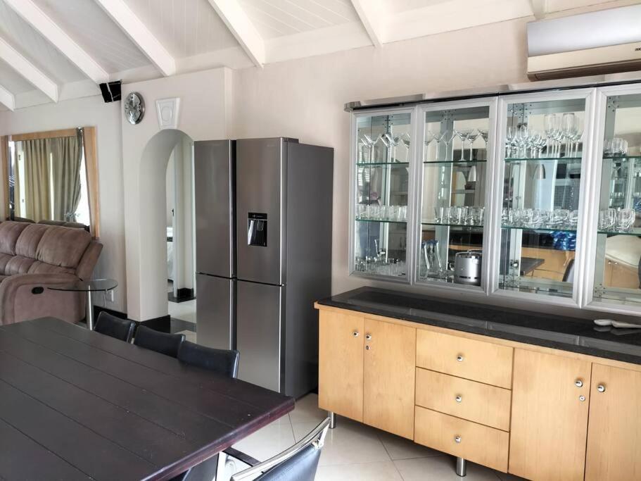a kitchen with a dining table and a refrigerator at Caribbean Estates Villa 7B in Port Edward