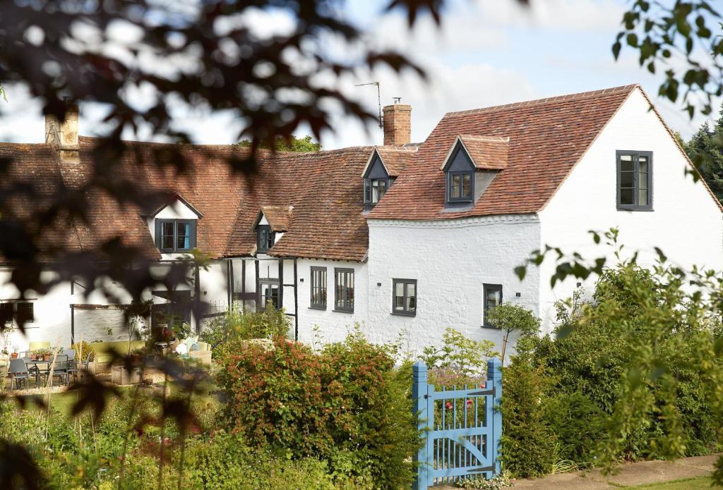 una casa blanca con una valla azul en The Dairy Worcestershire, en Eckington