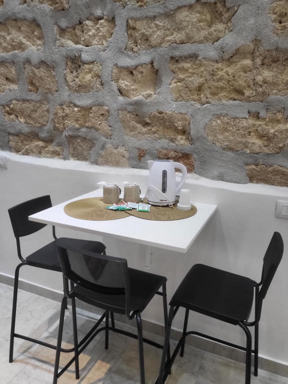a white table with chairs and a tea kettle on it at La casetta nel vicolo in Palermo