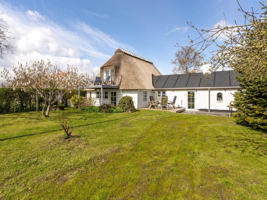 une maison au toit de chaume avec une cour d'herbe dans l'établissement Holiday Home Gyril - all inclusive - 100m from the sea by Interhome, à Sønderby