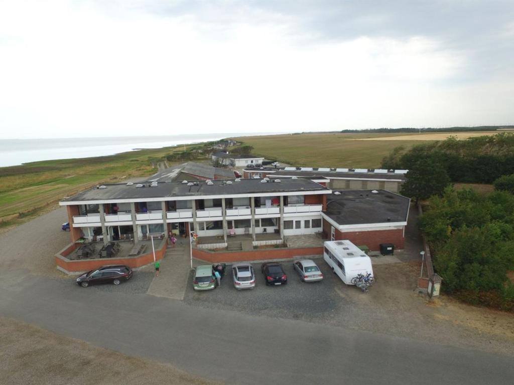 um grande edifício com carros estacionados num parque de estacionamento em Holiday Home Stilla - 35km from the sea in Western Jutland by Interhome em Højer