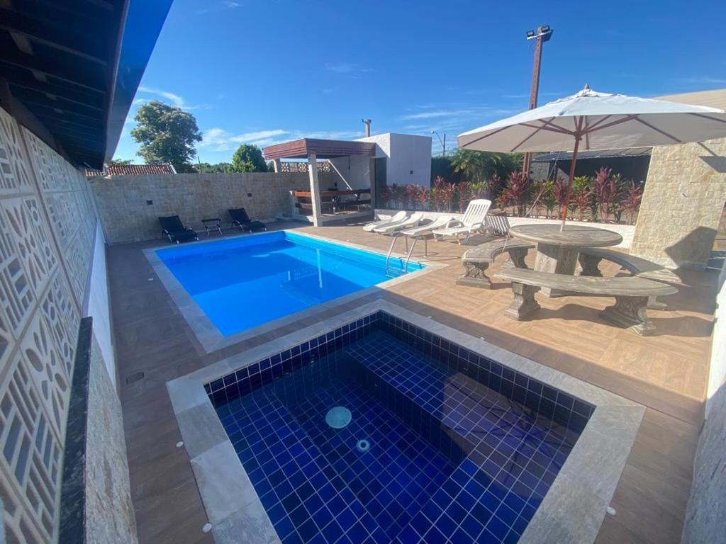 a swimming pool with a picnic table and an umbrella at Hotel Pousada Paraiso Avaré in Avaré