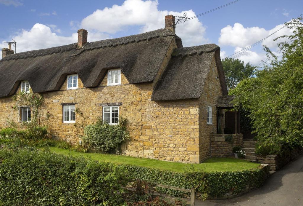 Cette ancienne maison en pierre est dotée d'un toit de chaume. dans l'établissement Harrowby End, à Ebrington