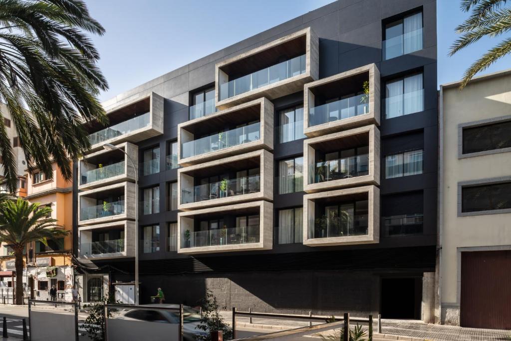 an apartment building with a black facade at TocToc Suites Olof Palme in Las Palmas de Gran Canaria