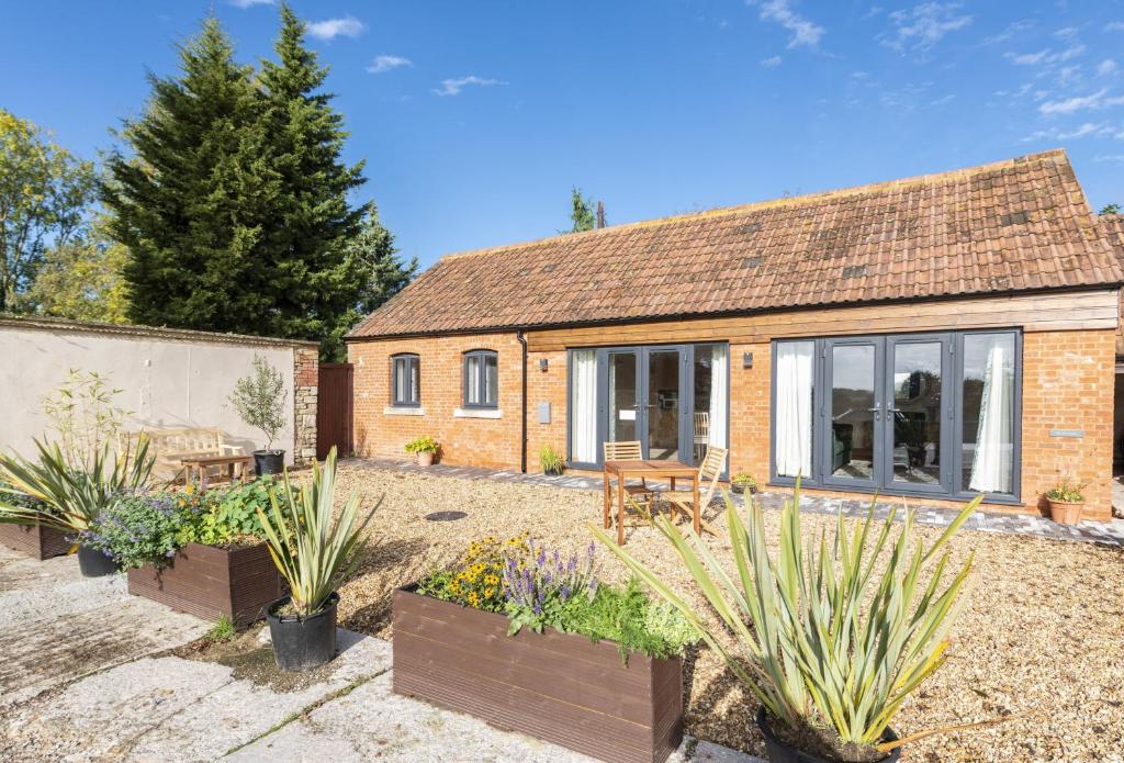 a cottage with a garden in front of it at The Old Stables at Bradley's Farm in Holt